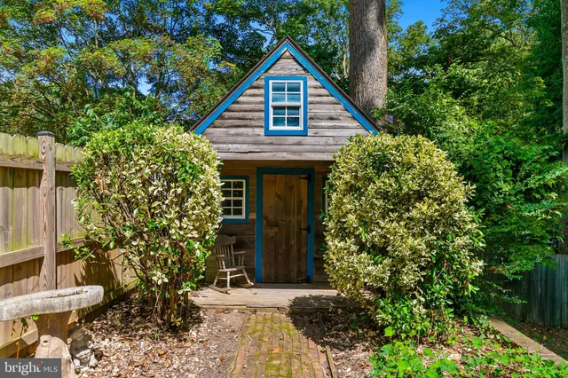 a view of a house with potted plants and a tree