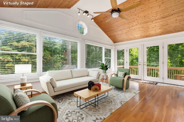 a living room with furniture and floor to ceiling windows