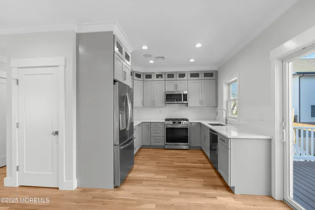 a kitchen with stainless steel appliances granite countertop a refrigerator and a stove top oven