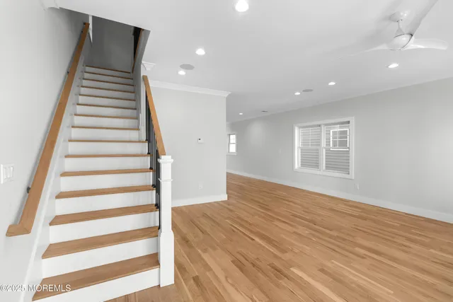 a view of a hallway with wooden floor and staircase