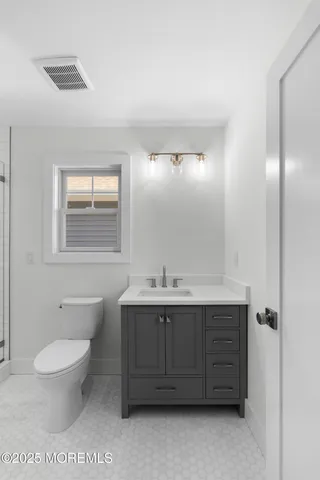 a bathroom with a toilet a sink and mirror