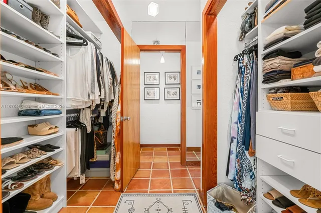 a view of walk in closet with clothes and shoes
