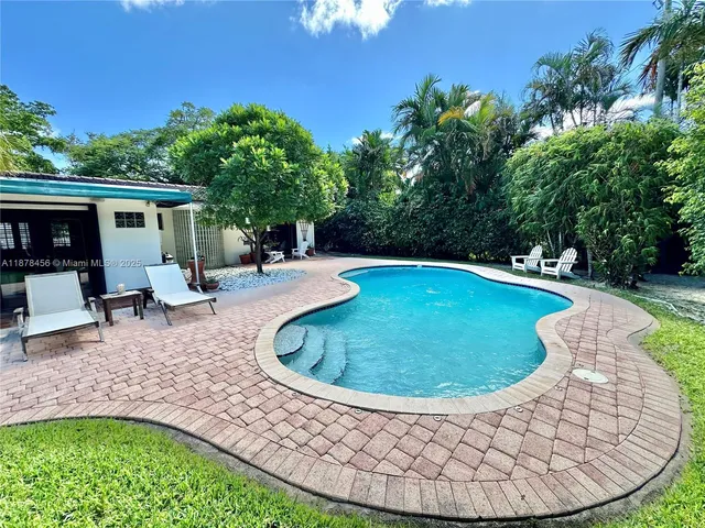 a view of a swimming pool with back yard of a house
