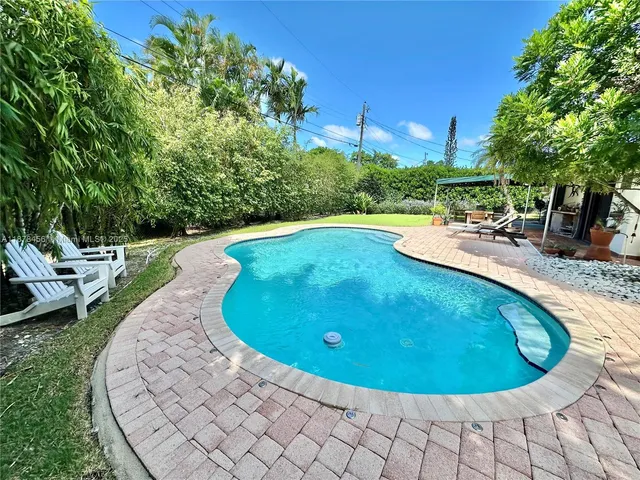 a view of a swimming pool with a yard and sitting area