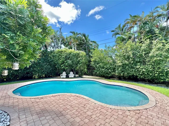 a view of a swimming pool and trees in the background