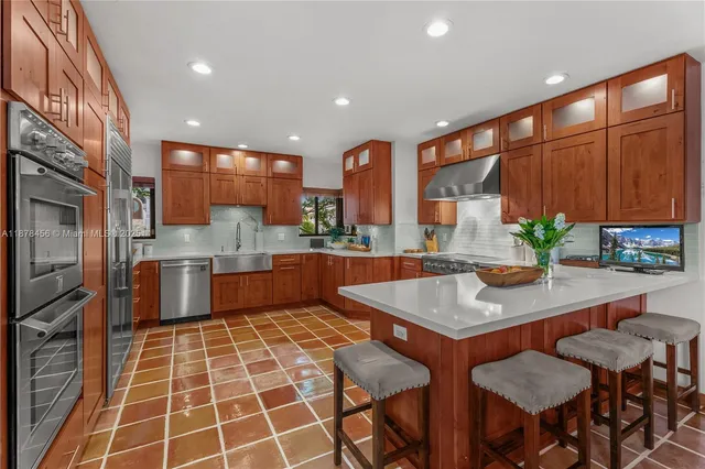 a kitchen with stainless steel appliances granite countertop a stove a sink and a refrigerator