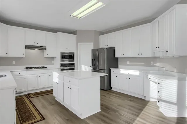 a kitchen with white cabinets and stainless steel appliances