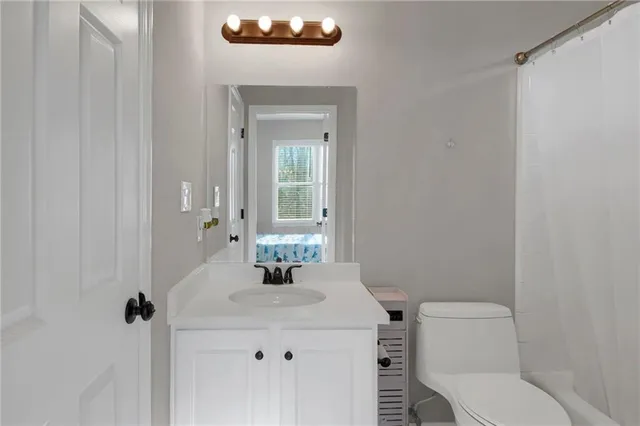 a bathroom with a sink vanity mirror and toilet