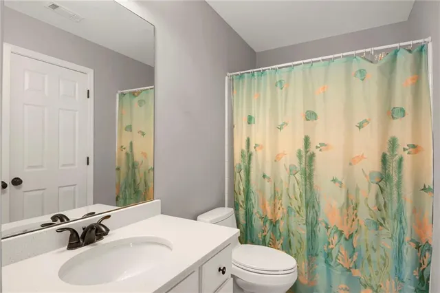 a bathroom with a sink a toilet and shower curtain