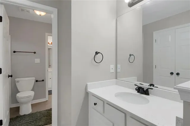 a bathroom with a sink a toilet and a mirror