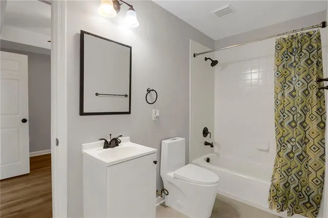 a bathroom with a bathtub shower sink mirror and toilet