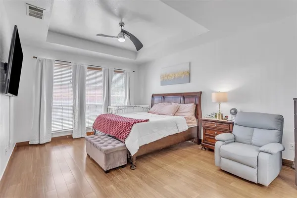 a spacious bedroom with a bed couch and window