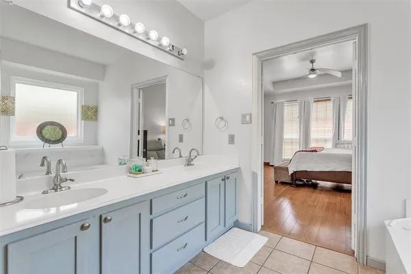 a en suite bathroom with a double vanity sink and a mirror