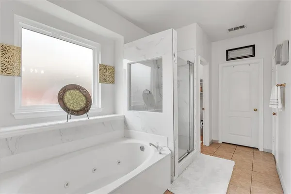 a bathroom with a tub a sink and a mirror