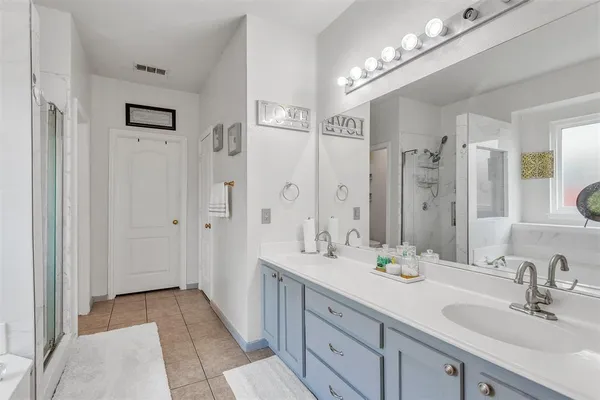 a bathroom with a double vanity sink shower and a mirror