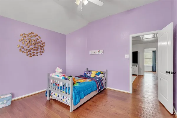 a bedroom with pink bed and wooden floor