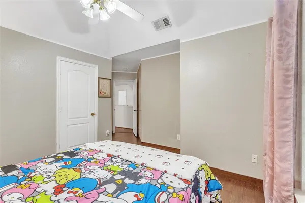 a bedroom with a bed and a chandelier fan