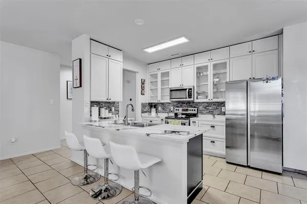 a kitchen with stainless steel appliances a sink cabinets and refrigerator