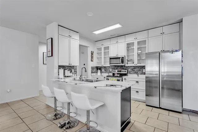a kitchen with stainless steel appliances a sink cabinets and refrigerator