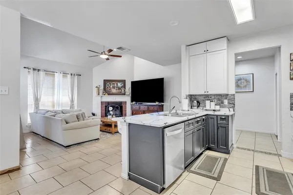 a living room with stainless steel appliances furniture and a flat screen tv