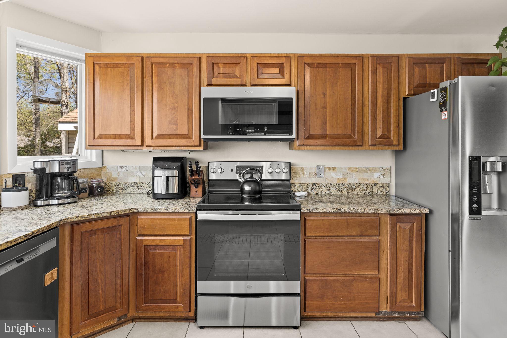 111 Chesterfield Court Locust Grove, VA 22508 - Photo 27 of 97 a kitchen with granite countertop a stove and a microwave