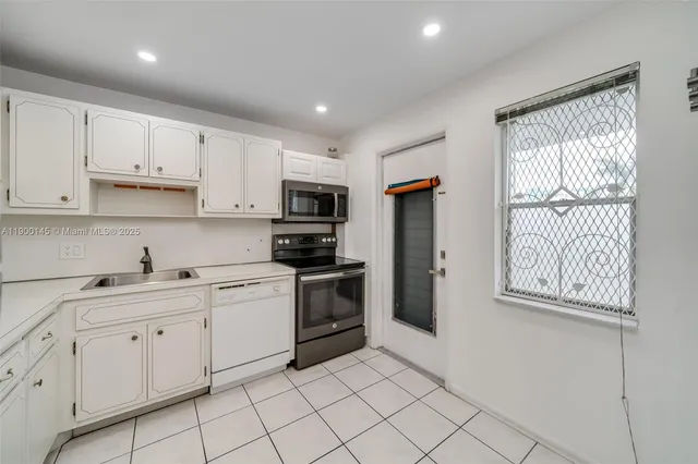 a kitchen with cabinets stainless steel appliances and a sink