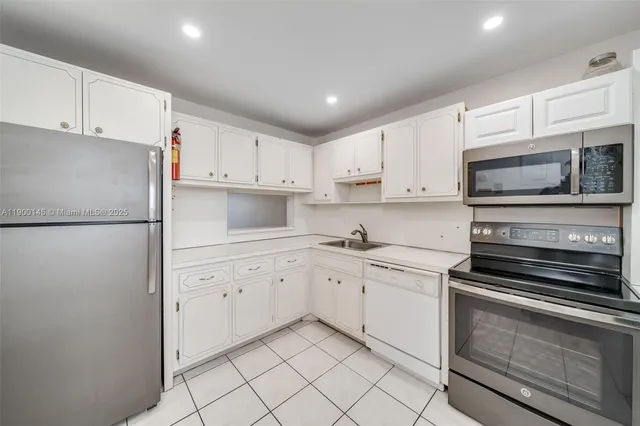 a kitchen with white cabinets and refrigerator