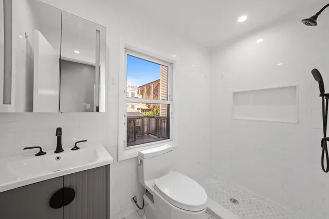 a bathroom with a toilet a sink and mirror