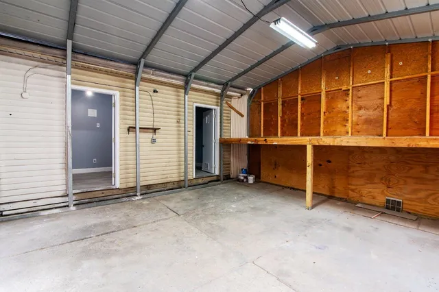 an empty room with washing machine and windows
