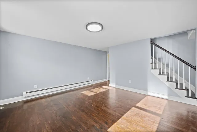 a view of an empty room with wooden floor