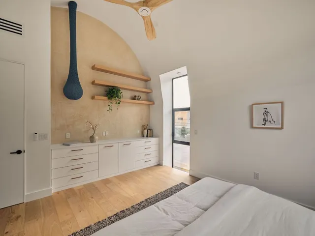 a spacious bedroom with a bed and a cabinets