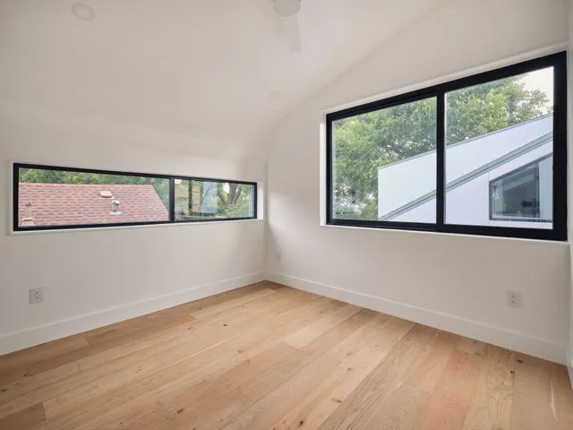 a view of a big room with wooden floor and windows