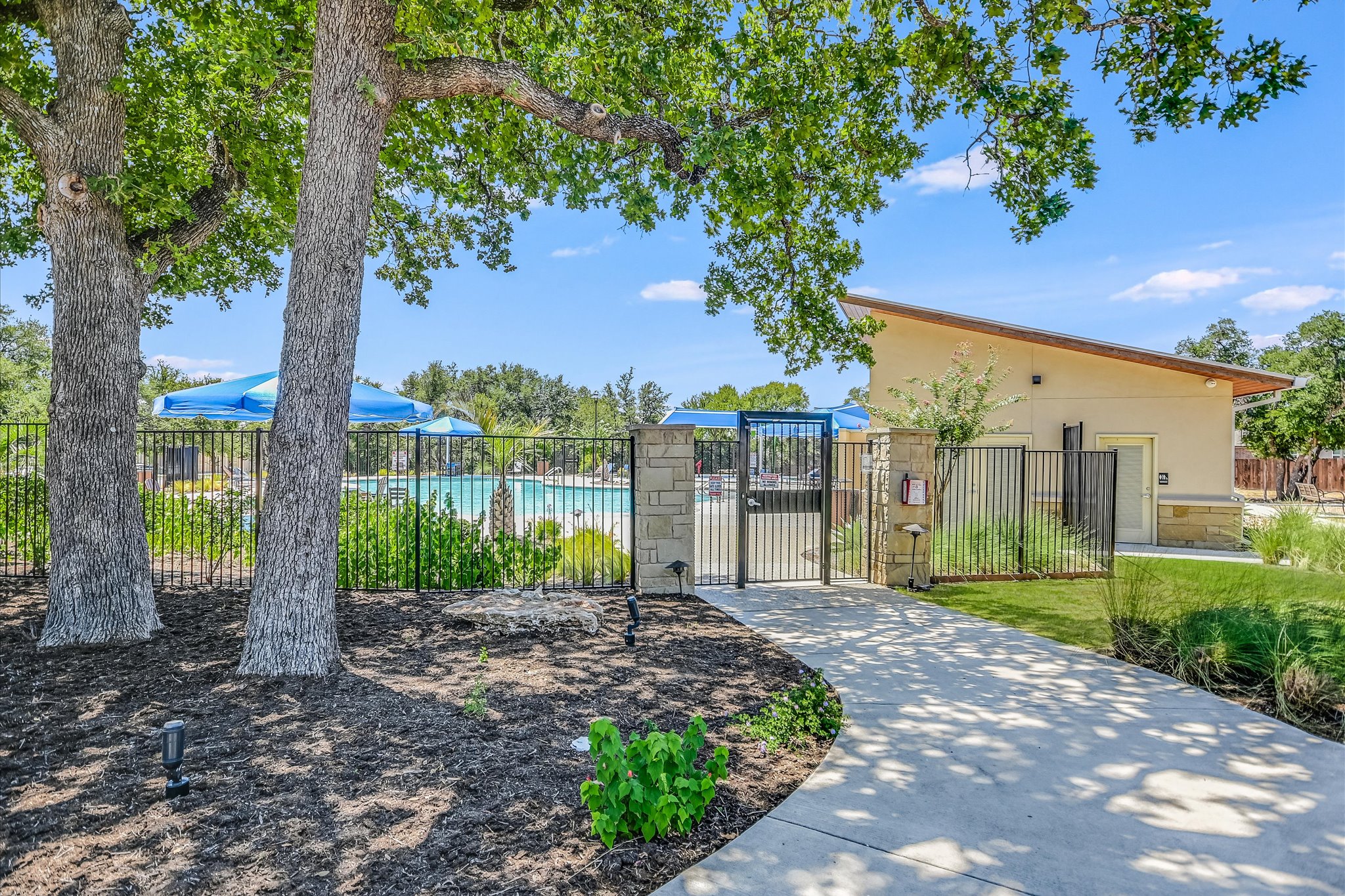 1701 Chapel Ranch Road Georgetown, TX 78628 - Photo 23 of 28 Mature trees shade a paved pathway leading to the gated community pool area.
