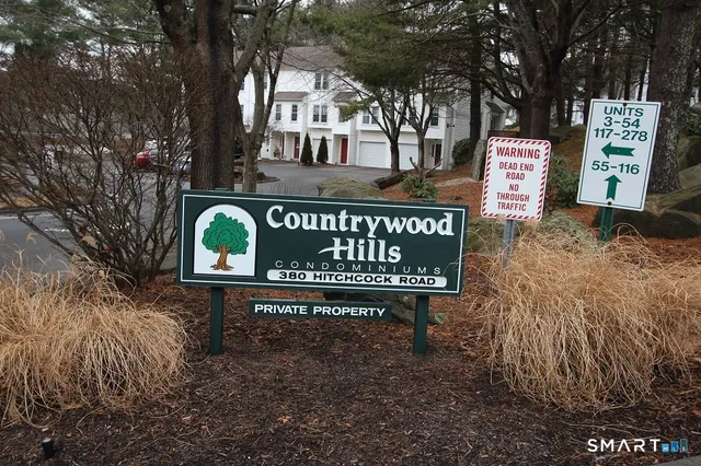 a view of a street sign board with large trees