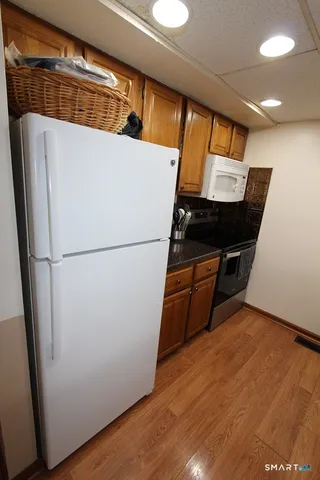 a view of kitchen with refrigerator and wooden floor