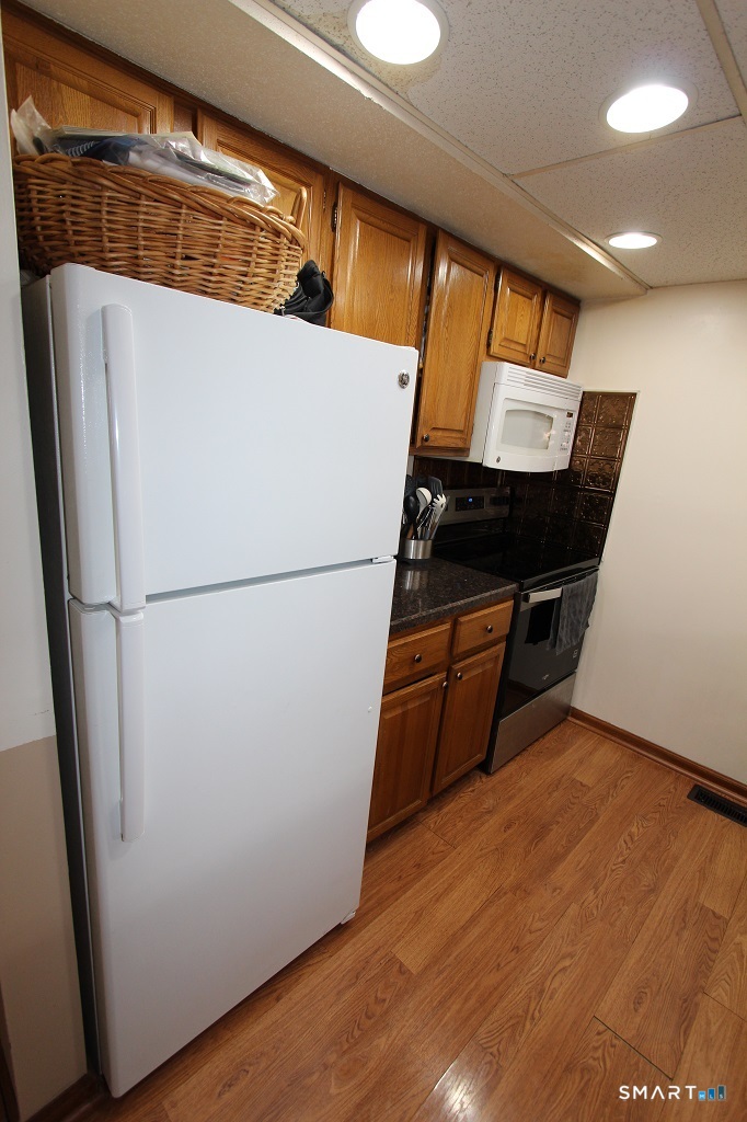 380 Hitchcock Road, Unit 47 Waterbury, CT 06705 - Photo 6 of 21 a view of kitchen with refrigerator and wooden floor