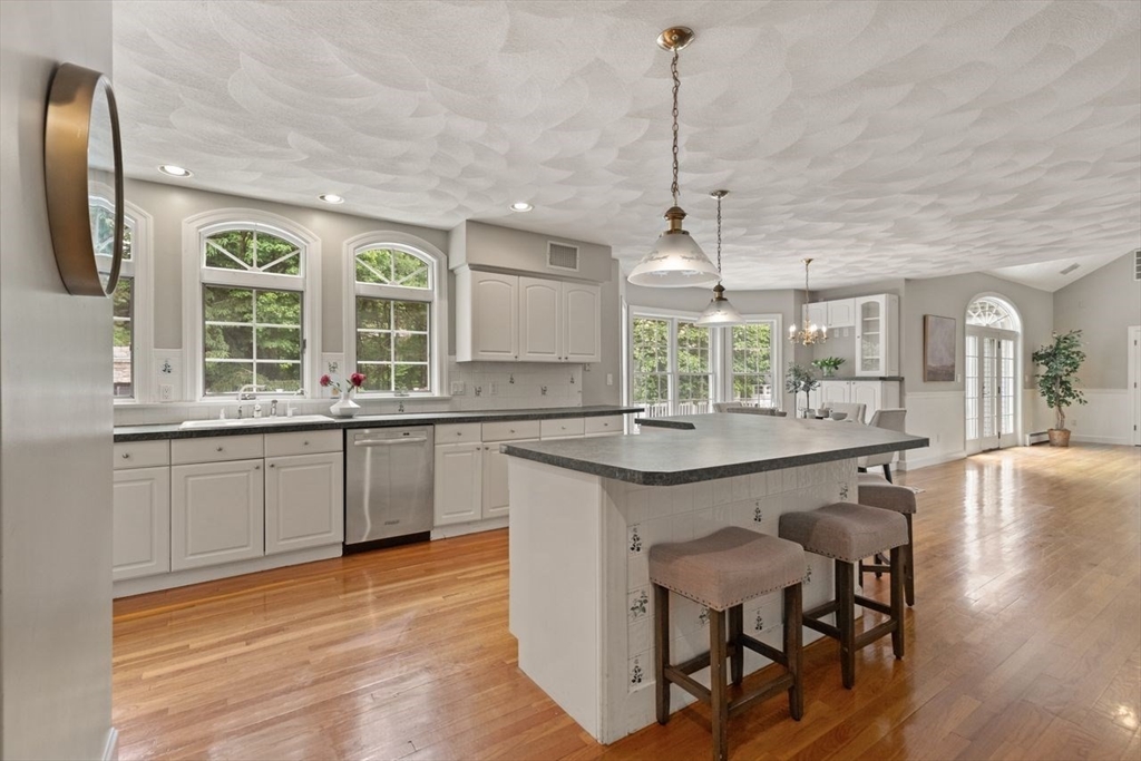 9 Mohawk Lane Lynnfield, MA 01940 - Photo 17 of 42 a kitchen with granite countertop a stove a sink a dining table and chairs
