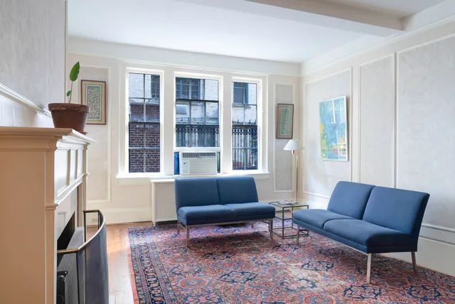 a living room with stainless steel appliances furniture and a window