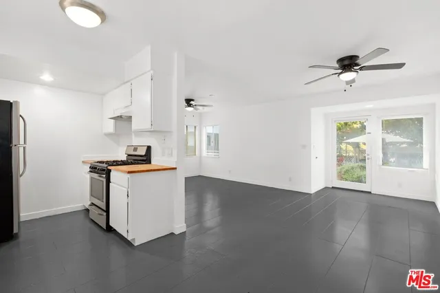 a view of kitchen with sink and refrigerator