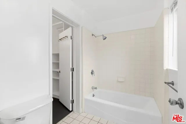 a bathroom with a bathtub door and shower
