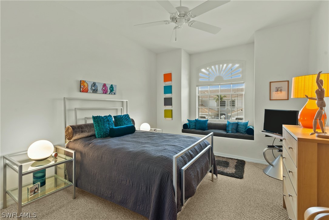 10013 Sky View Way, Unit 1705 Fort Myers, FL 33913 - Photo 11 of 24 a bedroom with a bed and a chandelier