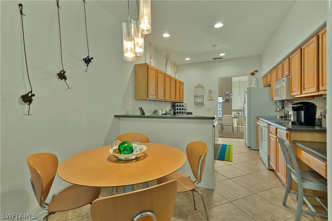 10013 Sky View Way, Unit 1705 Fort Myers, FL 33913 - Photo 7 of 24 a kitchen with stainless steel appliances granite countertop a sink a stove a dining table and chairs