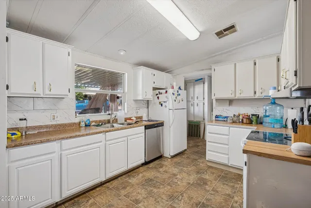 a kitchen with refrigerator and cabinets