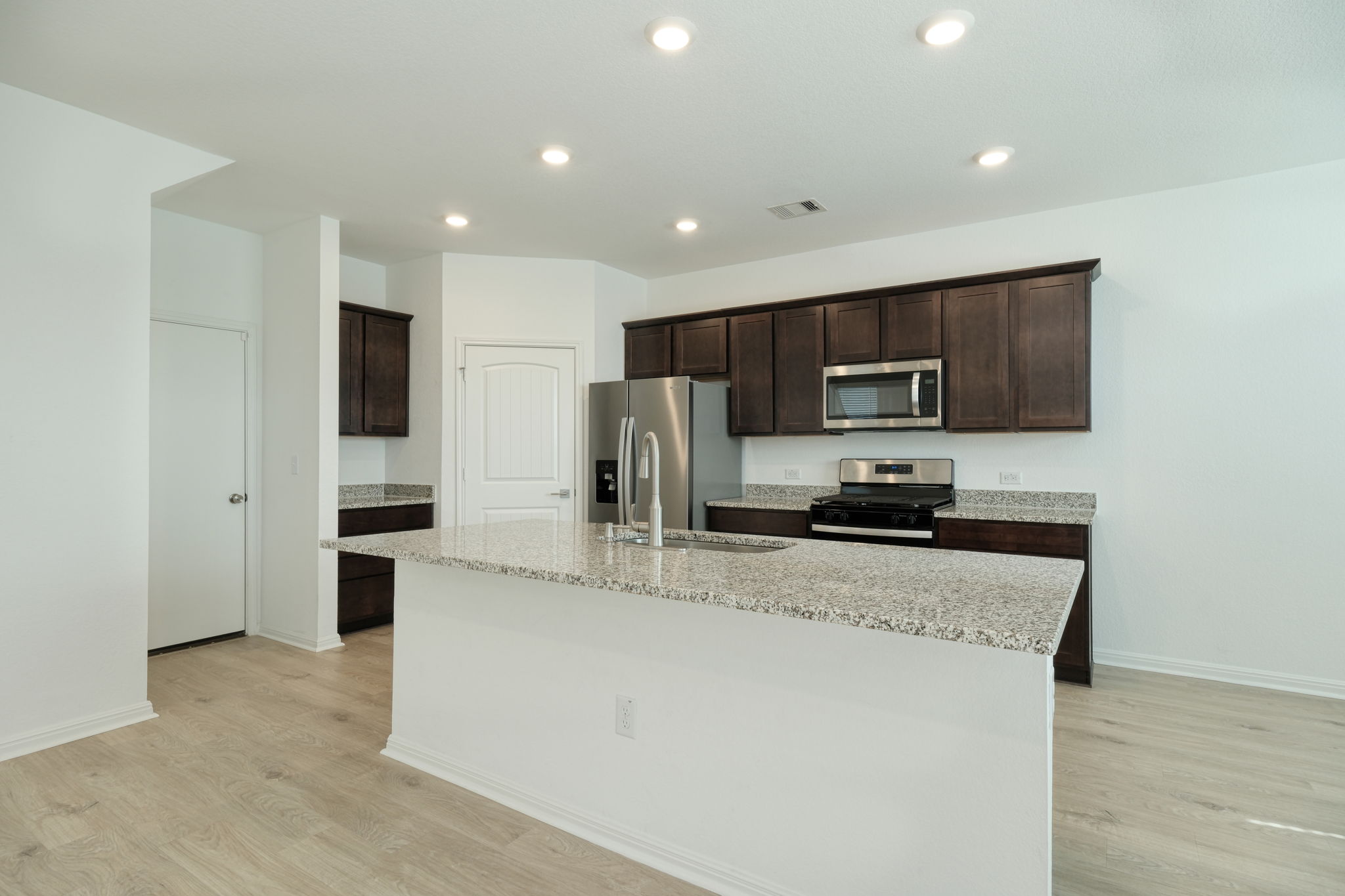 409 Brody Lane Georgetown, TX 78626 - Photo 3 of 14 a kitchen with stainless steel appliances granite countertop a refrigerator stove microwave and cabinets