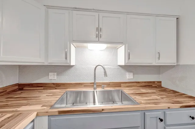 a kitchen with white cabinets and a sink