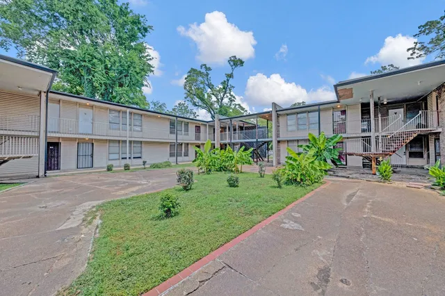 a view of a house with a yard and potted plants
