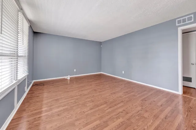 a view of empty room with wooden floor