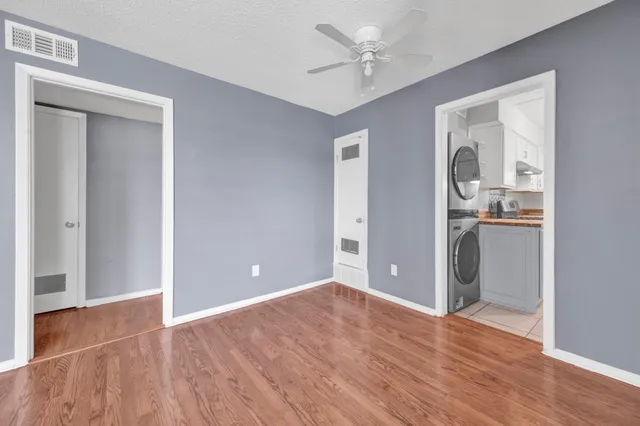 a view of empty room with wooden floor