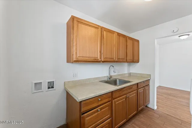 a kitchen with a sink a cabinets and wooden floor