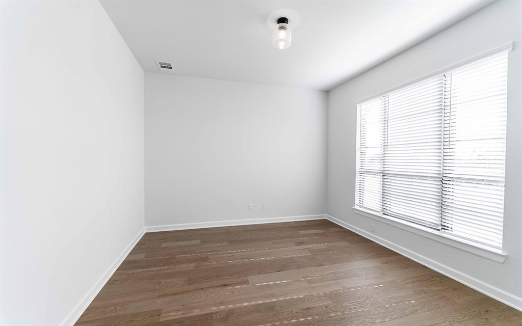 1916 Casting Ridge Mesquite, TX 75181 - Photo 2 of 26 an empty room with wooden floor and windows